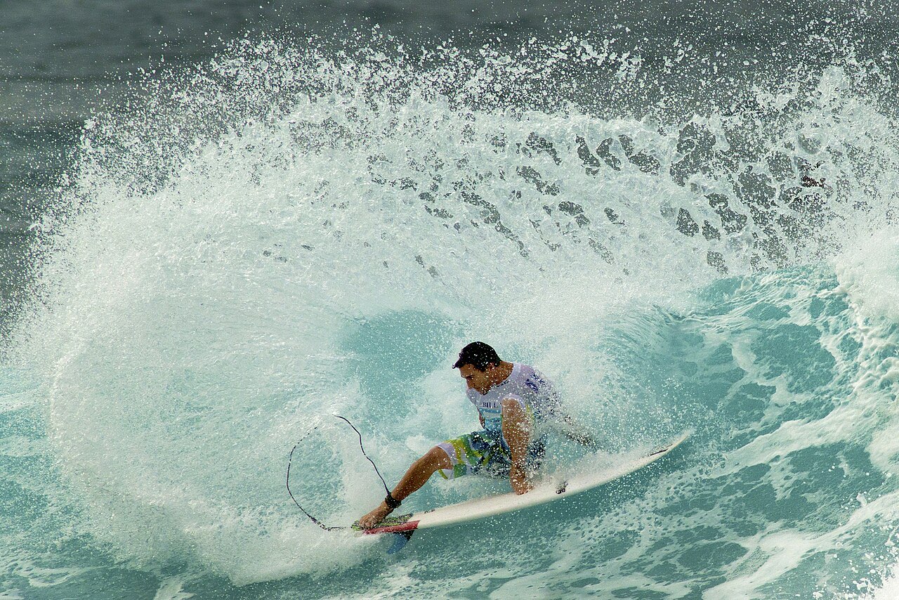 A surfer riding inside the barrel of a large breaking wave at the Pipe Masters on Oahu's North Shore